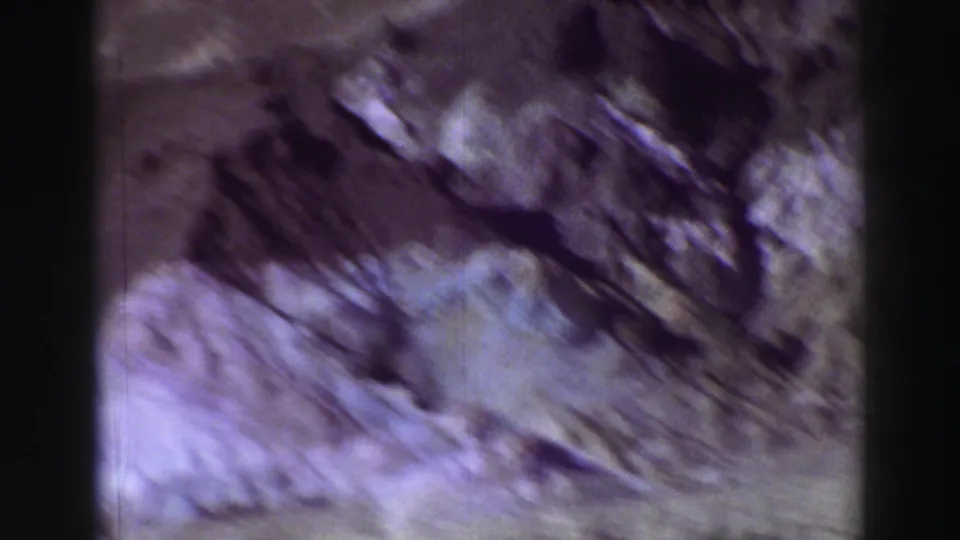 1969 8mm Lake Tahoe footage showing blurred rocky slopes and shadowed gullies under bright light.