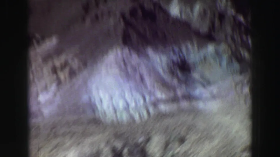1969 Lake Tahoe home-movie frame with motion blur across rocky slopes and faded 8mm color shifts.