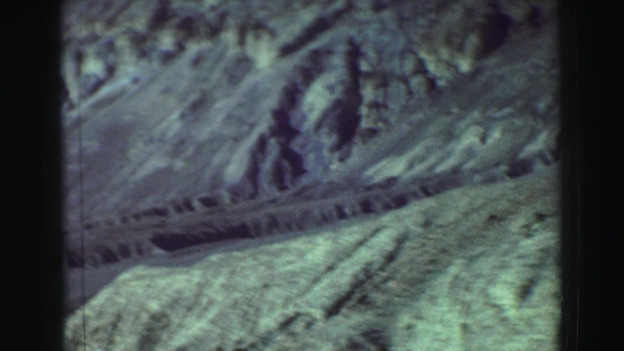 Rocky hillside with a pale dirt path crossing the frame.