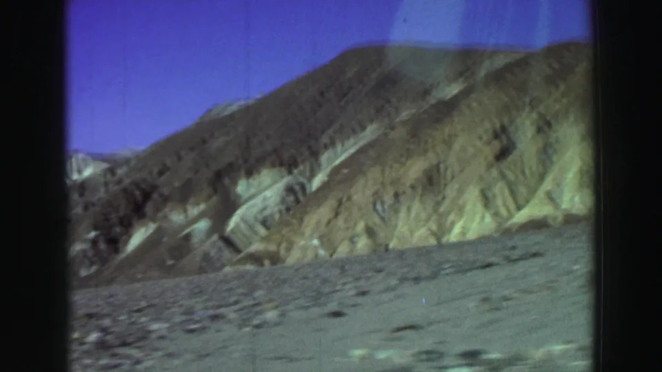 Color-shifted 8mm frame showing empty arid ridges and pale eroded gullies at the listed Lake Tahoe, California location.