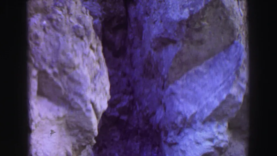 Lake Tahoe 1969 frame with close rock faces and a steep, narrow passage recorded in color-shifted 8mm home-movie footage.