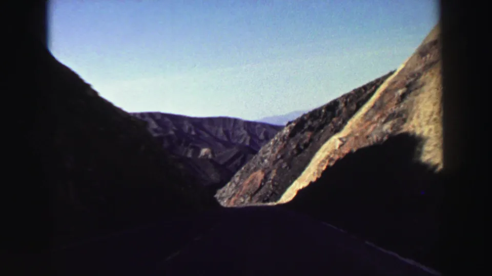 Near the end of the clip, the car interior silhouettes the Lake Tahoe-area mountain road and sunlit rocky hillside ahead.