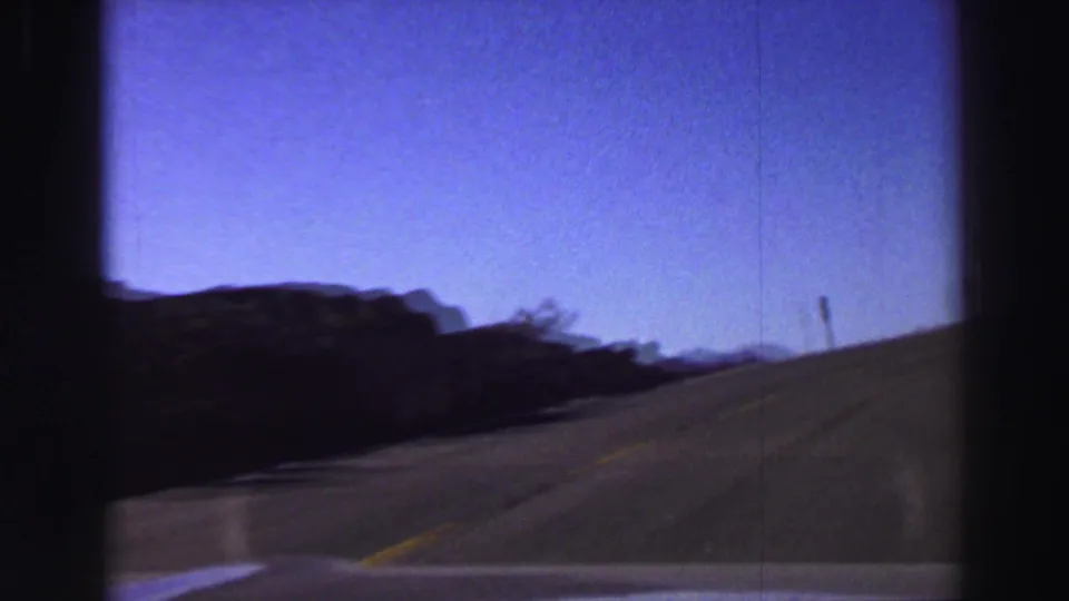 The final frame shows the car continuing along a Lake Tahoe mountain road with rocky ridge, yellow line, and roadside post.