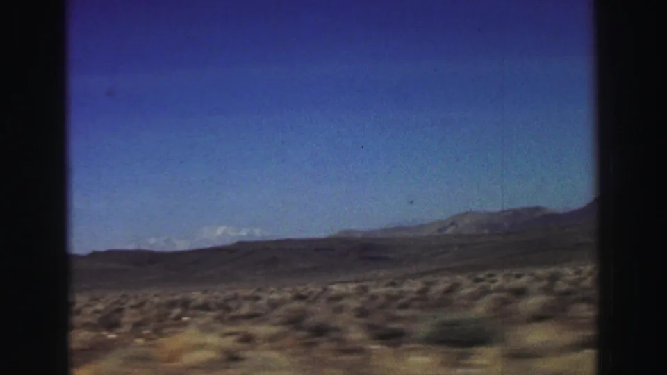 Wide 1969 8mm landscape view near Lake Tahoe with scrubland, distant mountains, and clear sky.