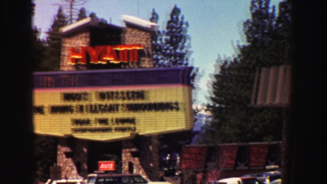 1969 Lake Tahoe hotel marquee advertising Hugo's Rotisserie and Sugar Pine Lounge, with pines and parked cars visible.