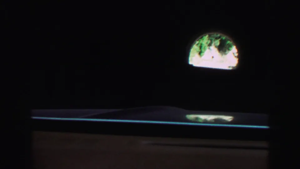 Inside the tunnel, the frame falls mostly into darkness while a bright arched exit and a strip of road remain visible ahead.