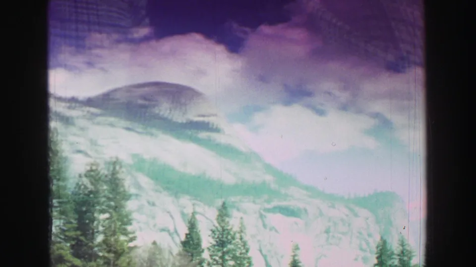 Lake Tahoe area mountain scenery appears in a faded 8mm frame, with granite ridges, pines, and bright cloud cover.