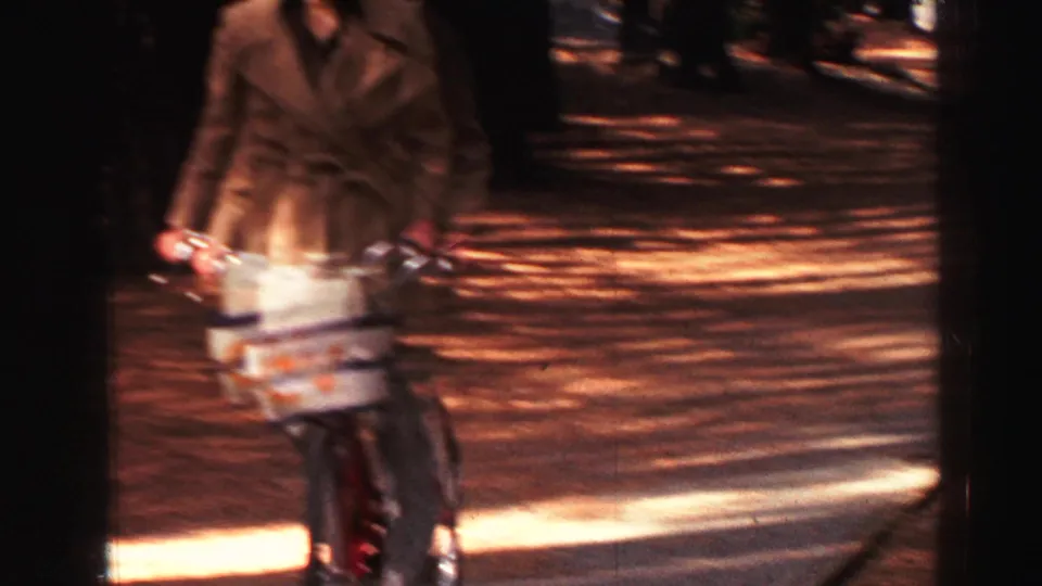 A blurred adult in a coat appears on a wooded Lake Tahoe path in this 1969 8mm home-movie frame.