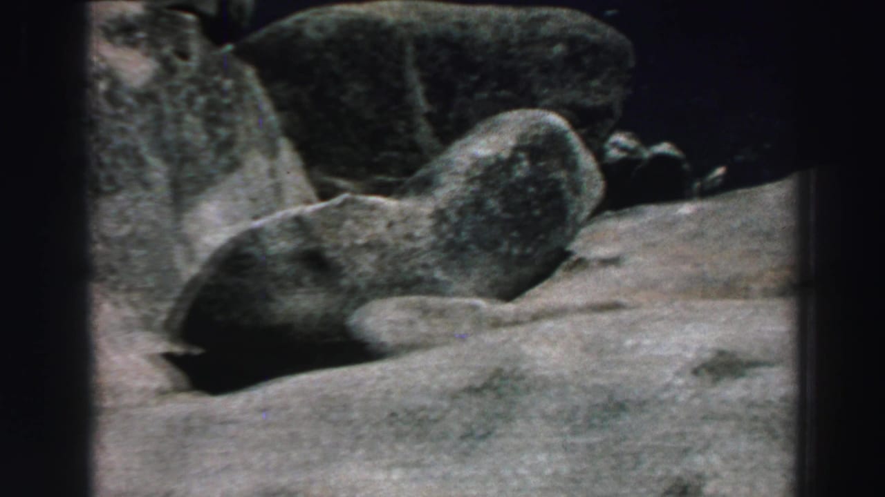 Large gray boulders and pale rock surfaces in a rugged outdoor setting.