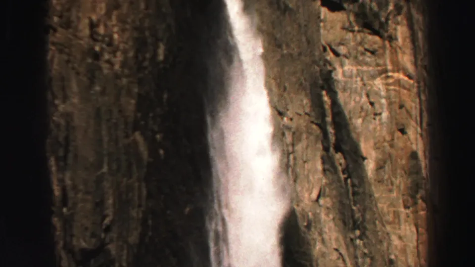 Lake Tahoe 1969 home-movie frame of a white waterfall against rugged rock, with warm color and visible grain.