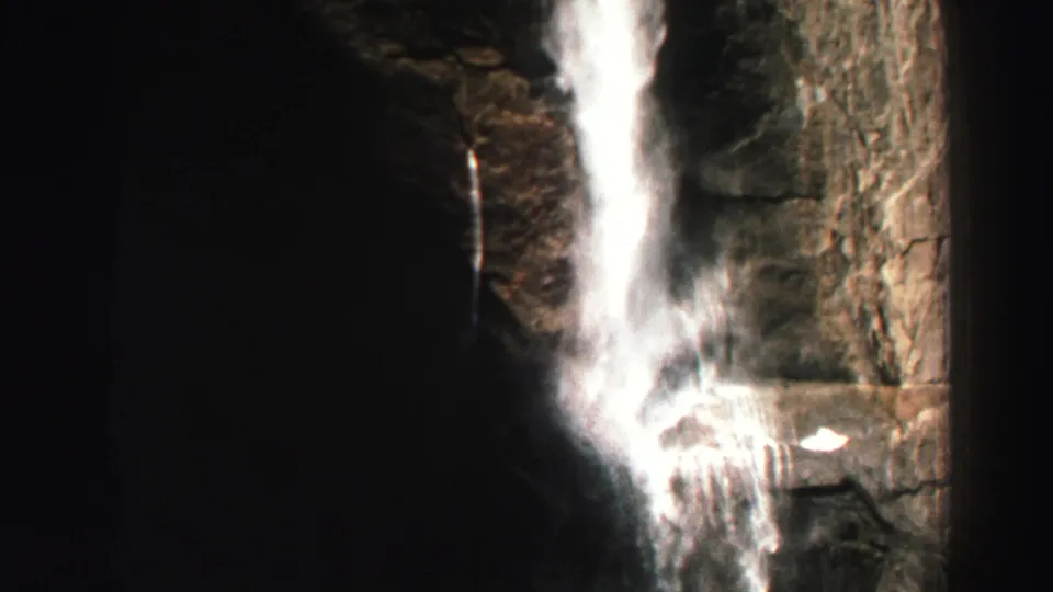 1969 Lake Tahoe waterfall shot with white water dropping through a shadowed rock face in a narrow canyon.