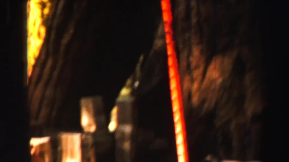 Dark final 8mm frame from the Lake Tahoe clip, showing an indistinct close surface with warm light and a thin red-orange vertical line.