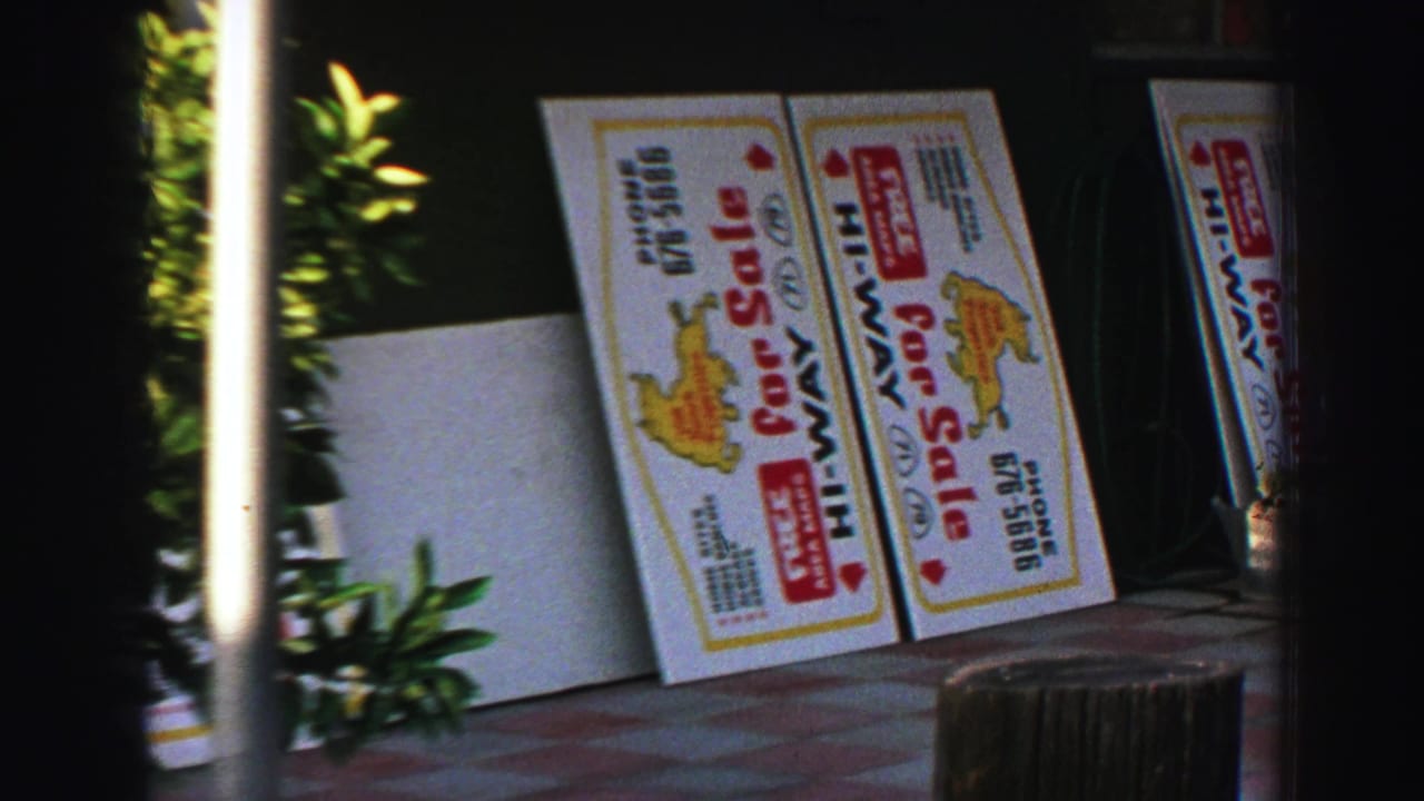 1969 Lake Tahoe sidewalk view with Hi-Way for sale signs, a small tree, and shaded storefront frontage.