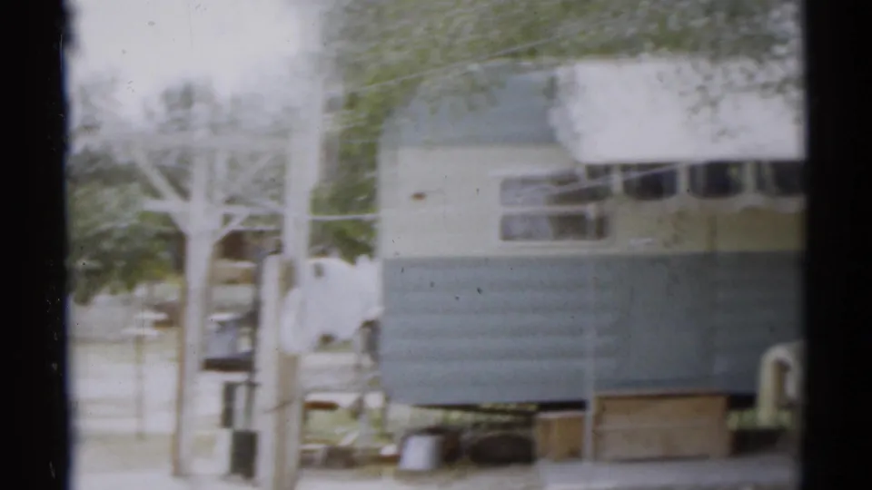 Trailer and surrounding parking-area structures at Disneyland, captured in soft 1959 8mm home-movie footage.
