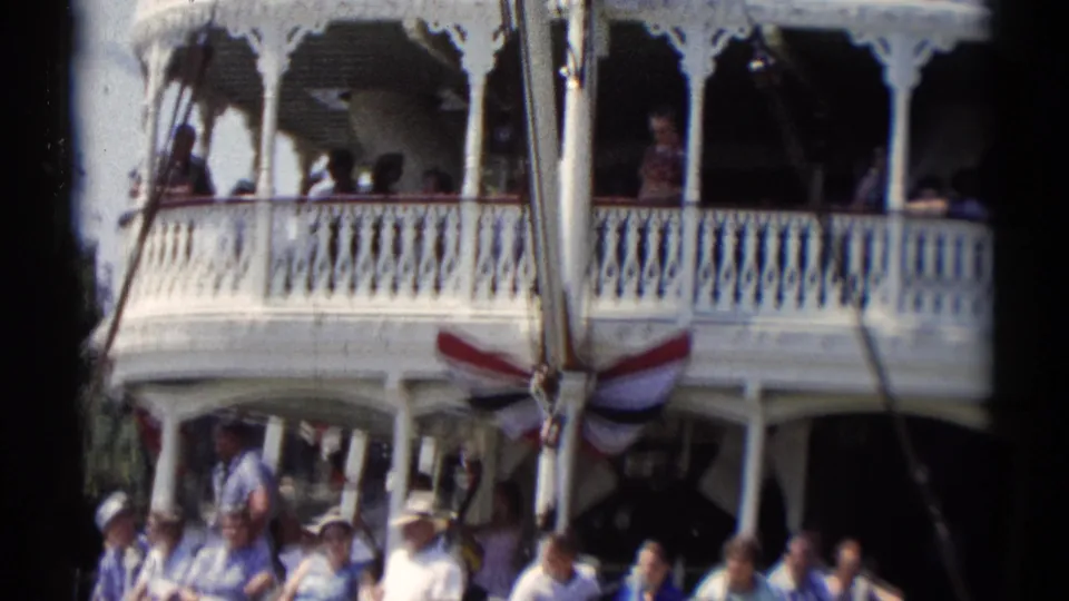 A closer 1959 Disneyland view shows the riverboat balcony, patriotic bunting, and passengers on upper and lower decks.