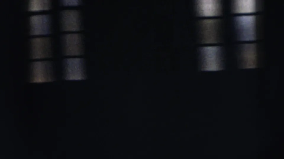 1962 Moline 8mm frame showing a very dark interior with barred window light and indistinct human silhouettes.
