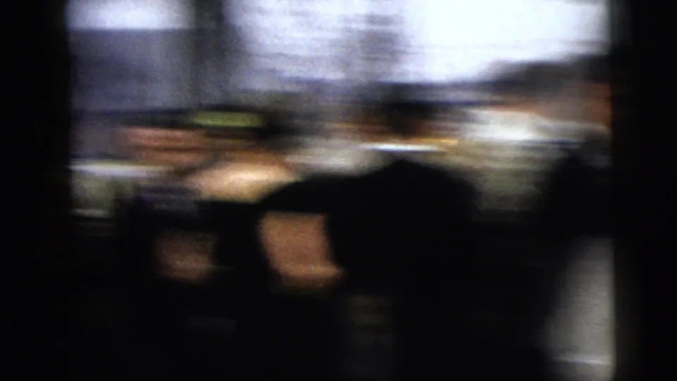 A motion-blurred 8mm frame shows wedding guests passing near cars and buildings in the Moline street setting.
