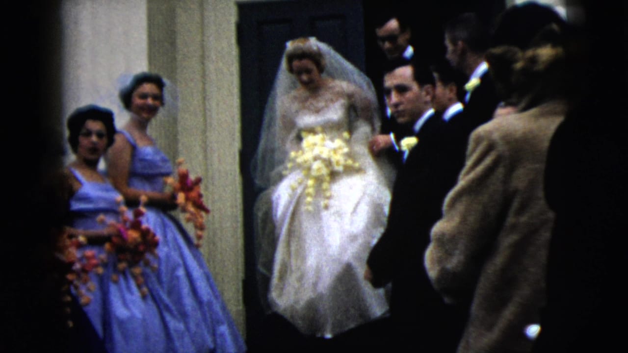 The bride moves out from the doorway while bridesmaids in blue dresses and suited men stand close by in the Moline wedding scene.