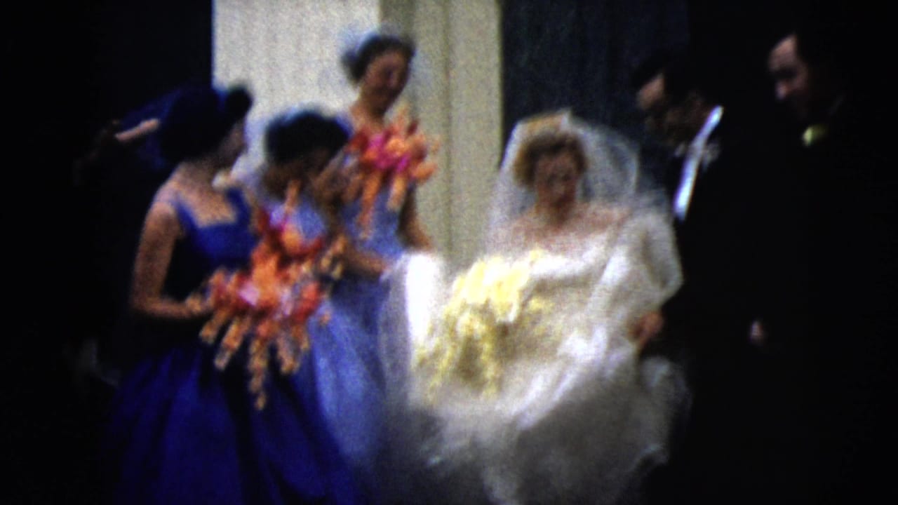 The 1962 Moline wedding party moves through the entrance, with the bride holding a pale bouquet and bridesmaids carrying colorful flowers.