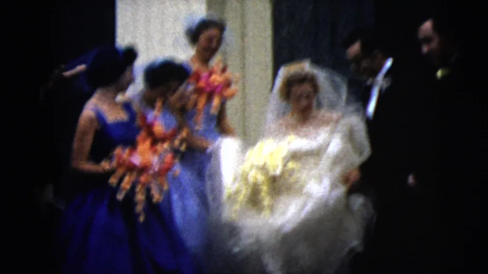 The 1962 Moline wedding party moves through the entrance, with the bride holding a pale bouquet and bridesmaids carrying colorful flowers.