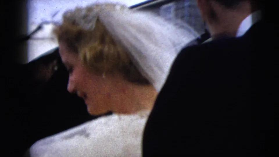 A side and rear view shows the bride's veil and light dress as she passes through a crowd at the Moline wedding.