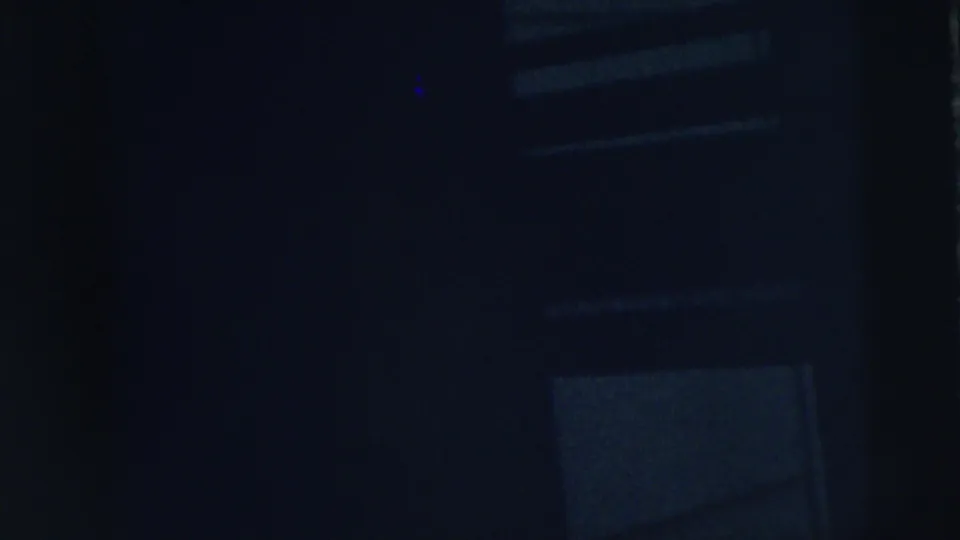 Very dark 1962 home-movie frame from Moline showing faint rectangular framing that may be a window, door, or wall panel in blue light.