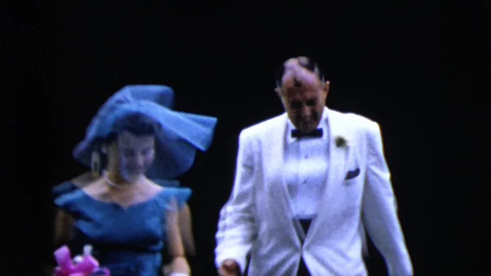 Late in the Moline wedding clip, the bride in veil and gown walks near an older man in a white jacket as rice appears at the side.