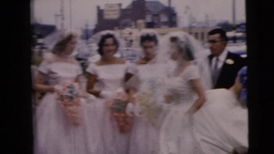 The bridal party appears slightly blurred in motion on a Moline sidewalk, with bridesmaids carrying bouquets and the bride in a white veil.