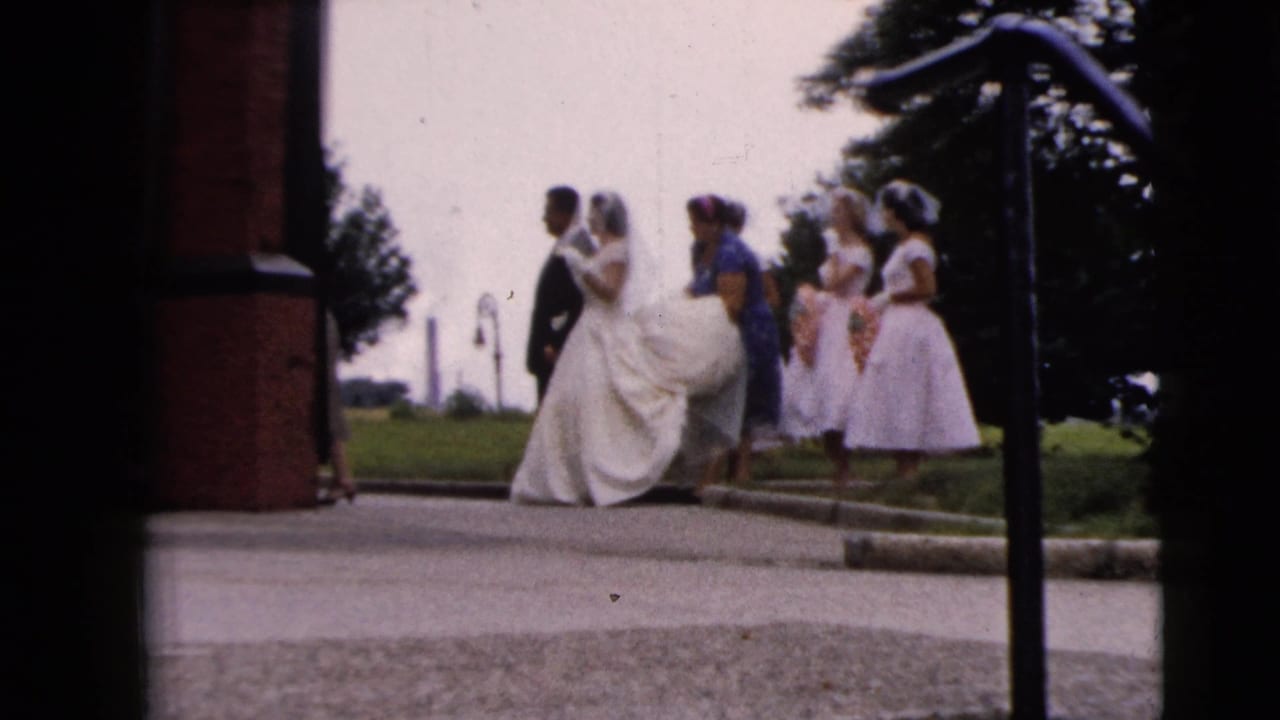 Bride and groom with bridesmaids outside a brick church entrance.