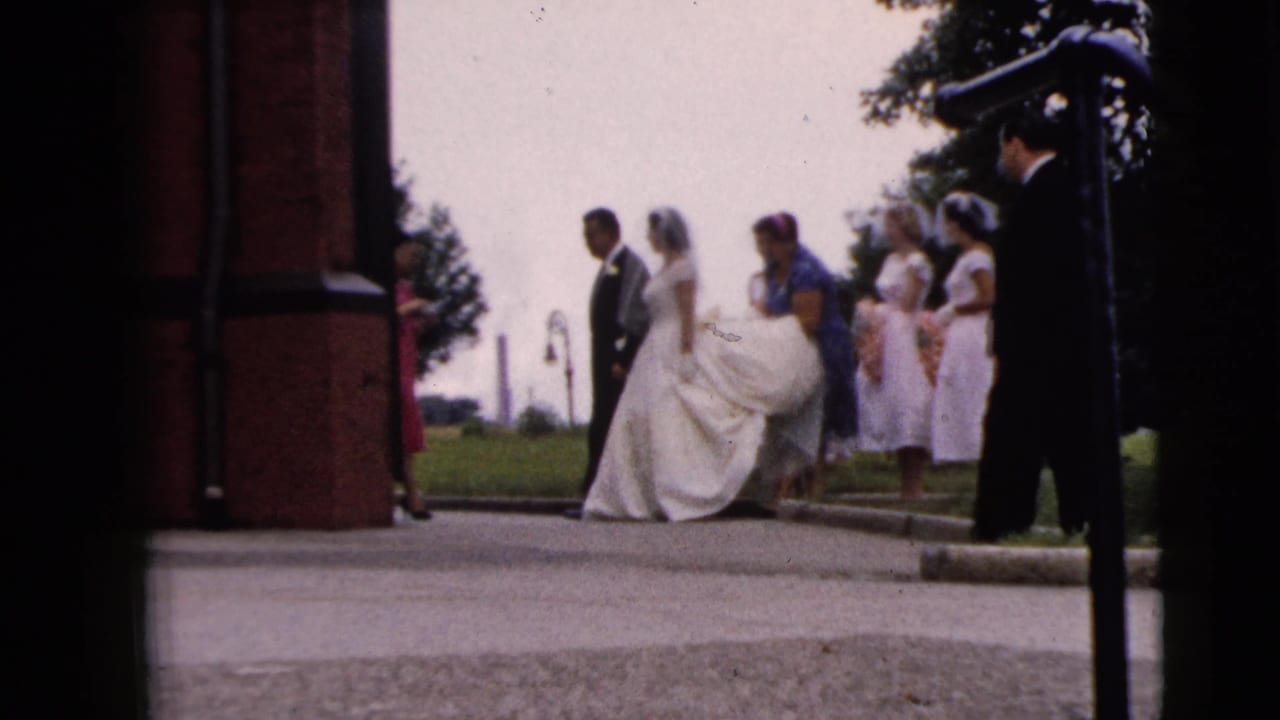 Bride in a white gown and veil stands with groom and attendants outside a brick church in Moline, Illinois, supported by clip metadata.