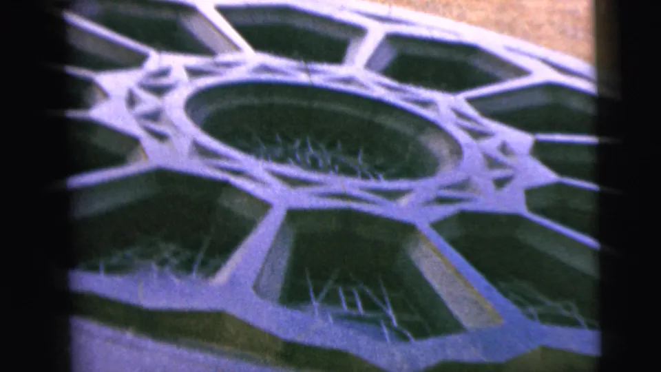 Close 8mm frame of a circular patterned church-front detail, with pale geometric framing around dark inset areas.