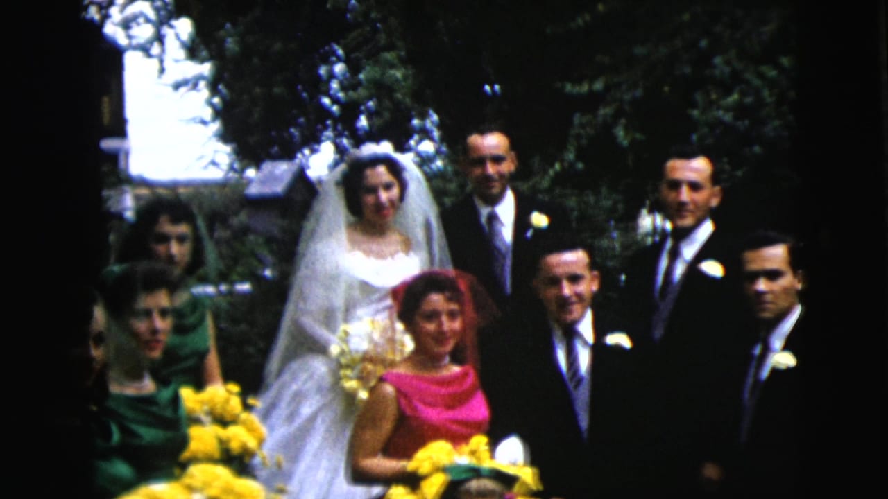 1962 Moline, Illinois wedding party posing outdoors, with the bride in a veil, suited men, bridesmaids in green, and yellow flowers.