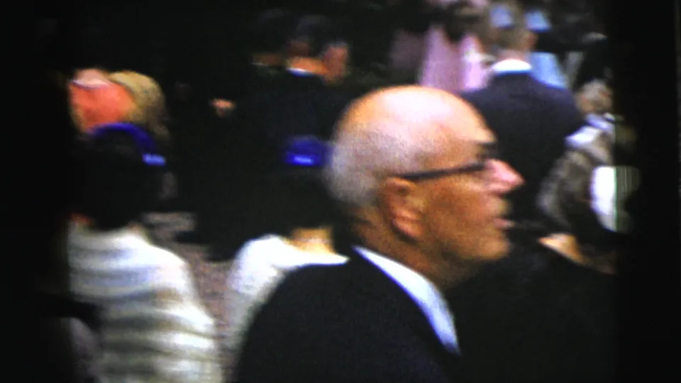 1962 Moline wedding frame showing an older male guest in glasses in profile, surrounded by blurred formal attendees.