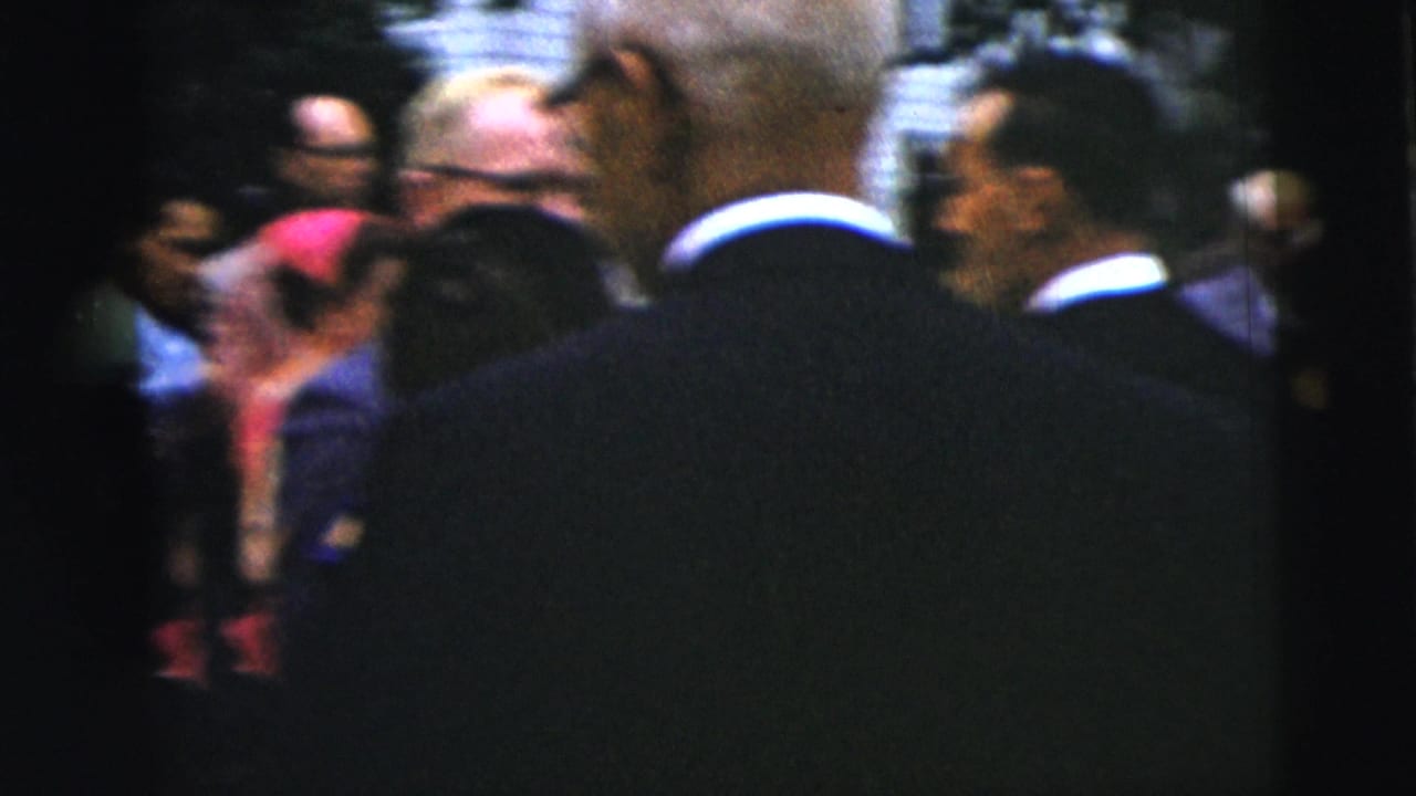 Suited men are seen from behind among guests outside a church-event crowd in Moline, Illinois, circa 1962.