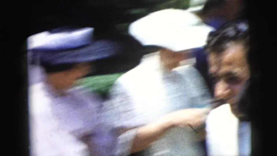 Guests in hats and formal clothing move past the handheld camera during the 1962 Moline church gathering.
