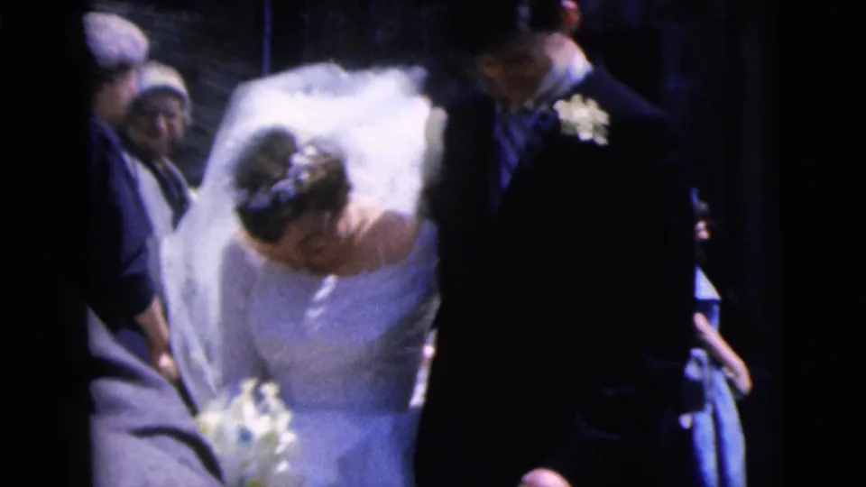 1962 Moline wedding frame showing the bride in a white gown and veil walking beside the groom among guests.