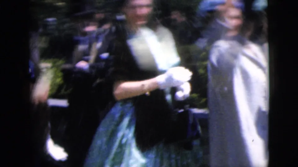 1962 Moline wedding guest scene with formally dressed adults outdoors, including a woman wearing gloves and a light coat.