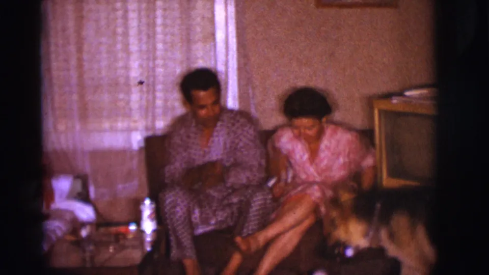1966 Clarkdale living-room frame with two adults seated on a couch while a German Shepherd-type dog stands in front of them.