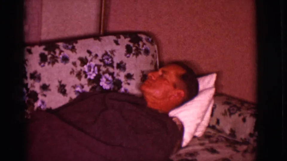At the end of the clip, the man remains lying on the floral sofa in the dim 1966 Clarkdale interior.