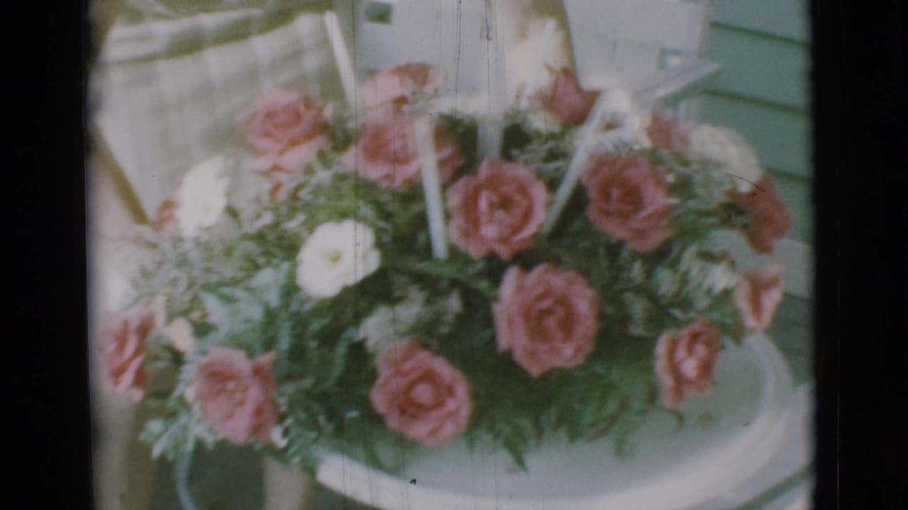 1966 Clarkdale 8mm frame showing a pink and white rose arrangement on a white circular tray.
