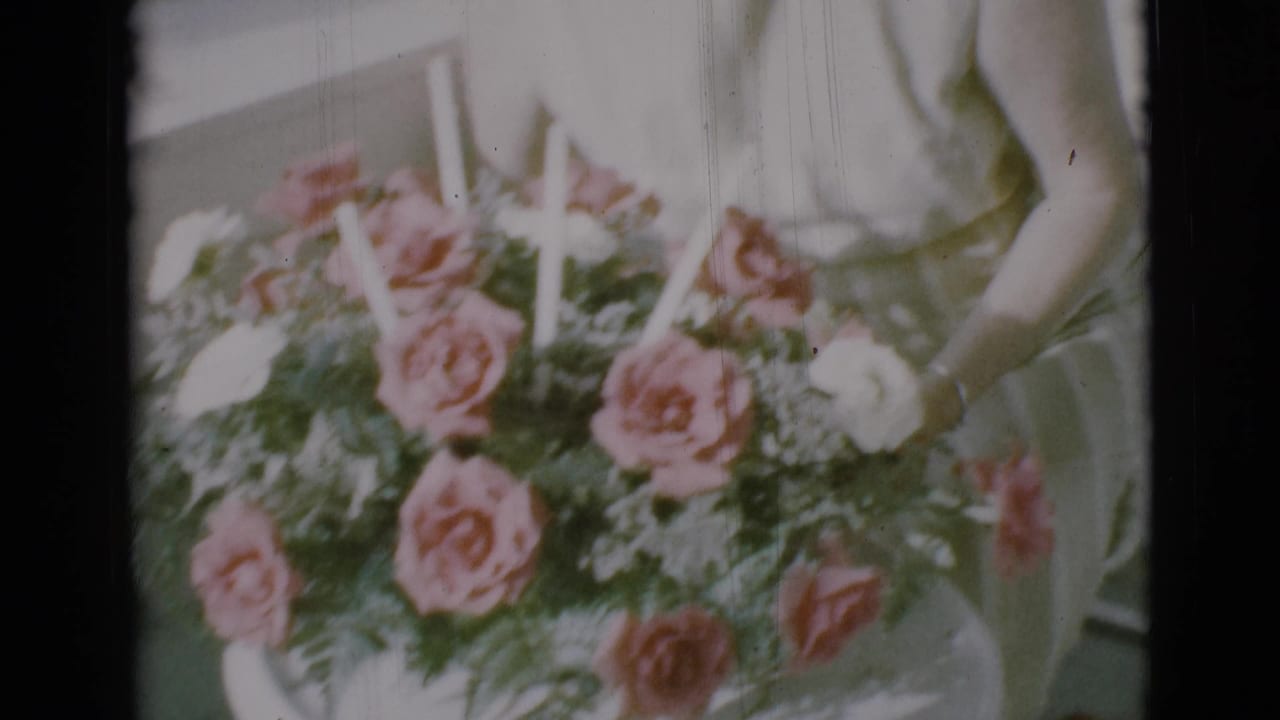 Woman's torso and hands near a rose bouquet on a porch chair.