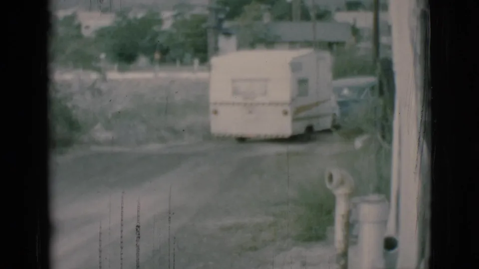 By the end of the clip, the caravan trailer and sedan are small in the distance on the Clarkdale dirt road.