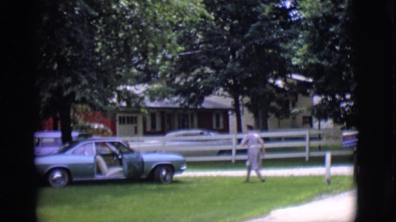 Woman near a light blue parked car with the passenger door open.