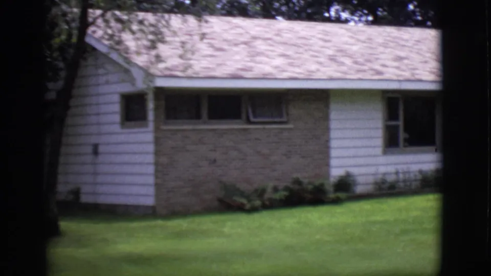 1966 Clarkdale, Arizona 8mm frame showing a ranch-style house with brick facade, white siding, narrow windows, and a green lawn.