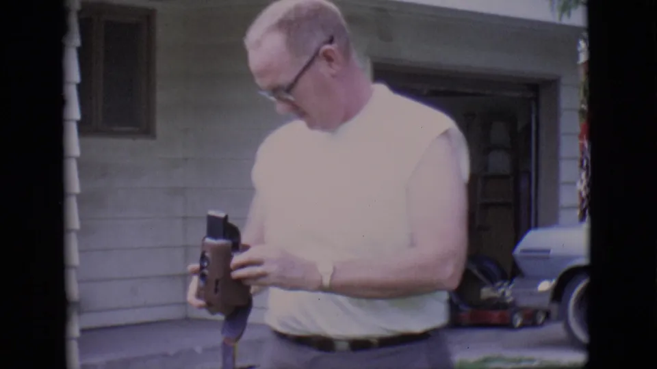 In the 1966 Clarkdale yard scene, the man looks down at the small movie camera near the porch and open garage.