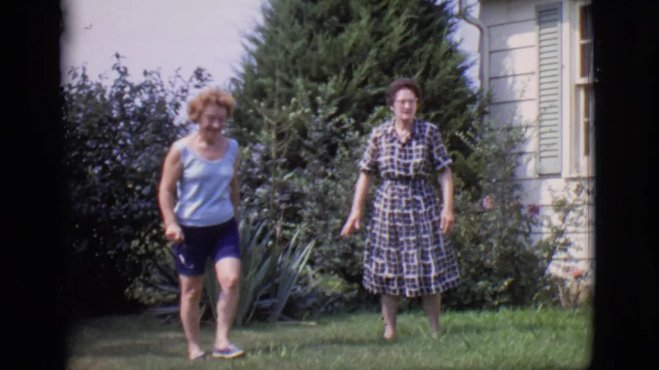 In Clarkdale, Arizona home-movie footage from 1966, two women walk through a backyard garden beside a white house with green shutters.