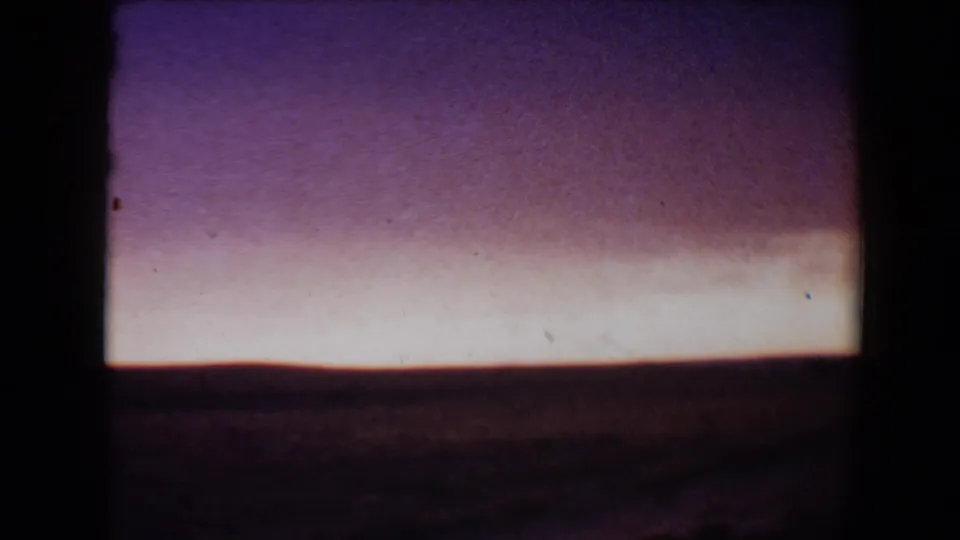 Flagstaff, Arizona dusk view on 8mm film, with a broad purple sky, pale horizon band, and dark landscape below.