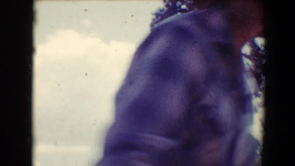 The final frame shows a close, partial view of a person moving past the camera, with bright sky and trees behind them.