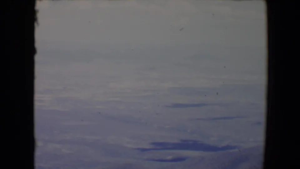 Wide 1967 8mm Flagstaff-area view showing distant terrain, dark lake forms, haze, and visible contact-sheet film borders.