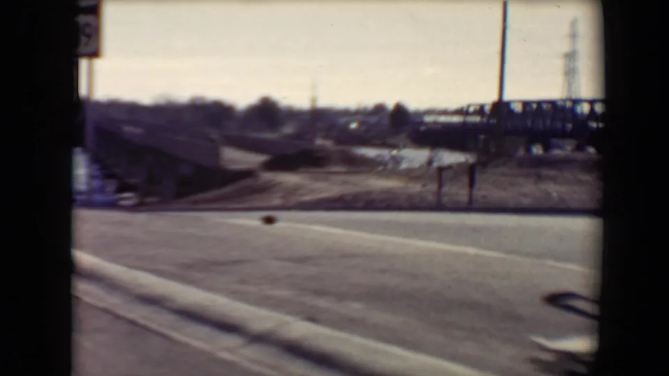 The clip ends on a brief exterior view of a road, roadside posts, distant structures, and utility poles in the Flagstaff area.